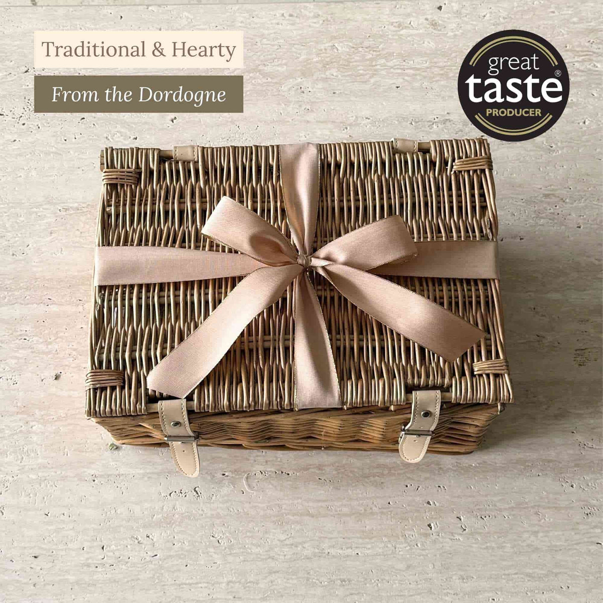 Tariette Barnabé Dordogne gift hamper in a closed wicker basket tied with a peach ribbon.
