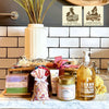 Box Les Bains captures the essence of Provence with artisan soaps, a scented candle, liquid hand soap, an olive wood dish, and a bunch of lavender.