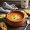 Bowl of soup with garlic bread on a wooden table