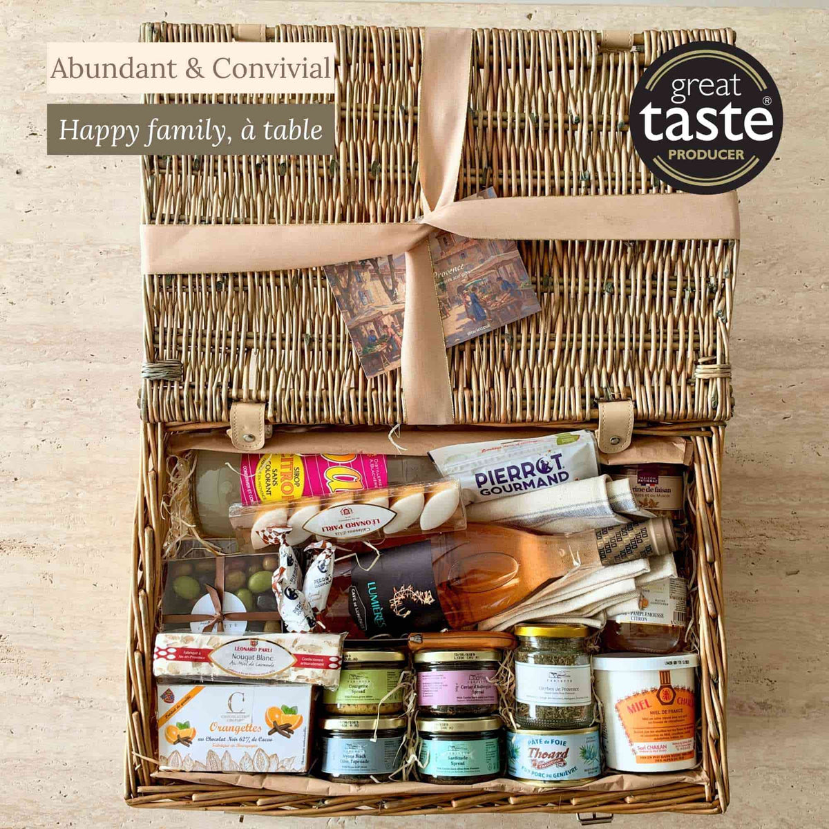 Tariette Paulette family food hamper open with rosé wine, French sweets, terrines, savoury spreads, honey and a Laguiole spread knife.