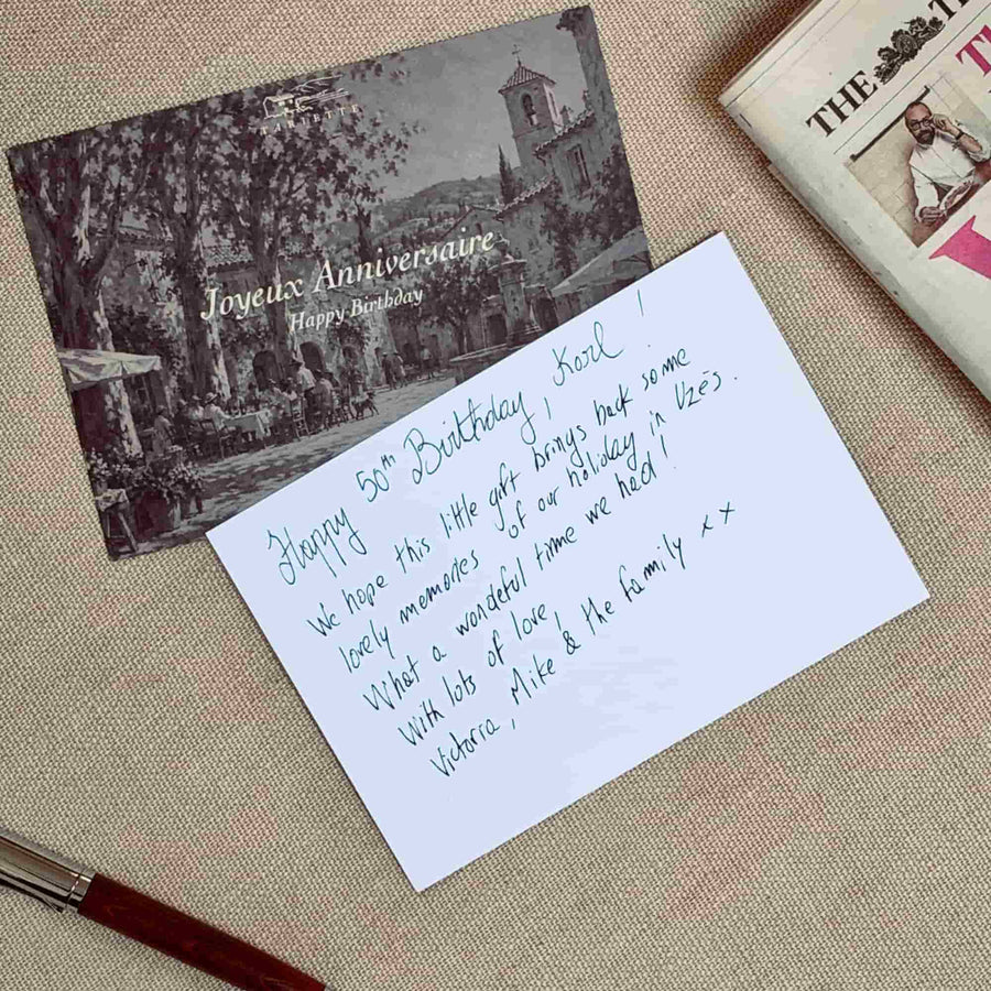 Tariette Joyeux Anniversaire birthday greeting card beside a handwritten 50th birthday message, on natural linen with a pen.