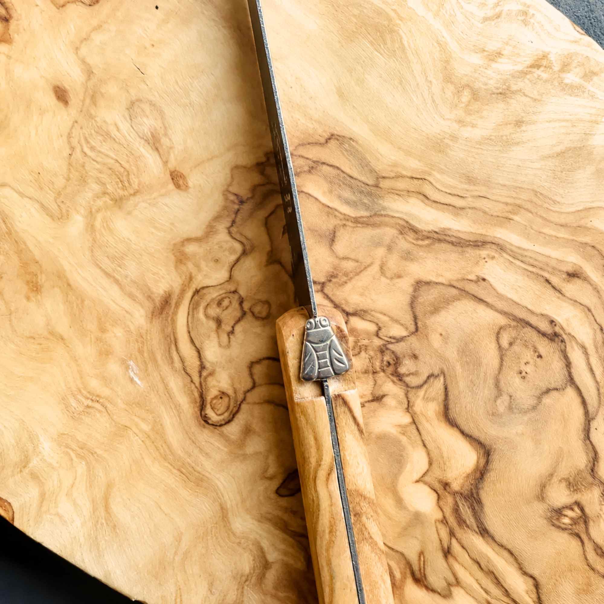 Laguiole cheese knife on olive wood cheese board