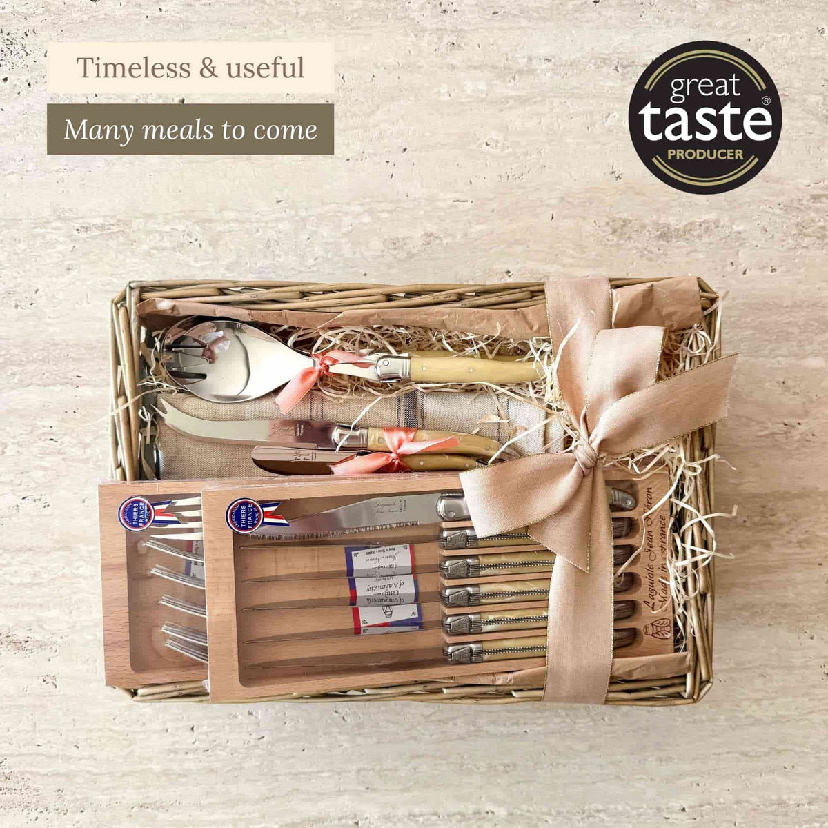 Tariette Laguiole cutlery gift basket with boxed knives and forks, salad servers, cheese and butter knives and a linen tea towel.
