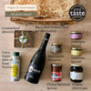 Lio vegan hamper contents laid out: red wine, olive oil, almonds, aubergine and artichoke spreads, hummus, chocolate spread and jam.