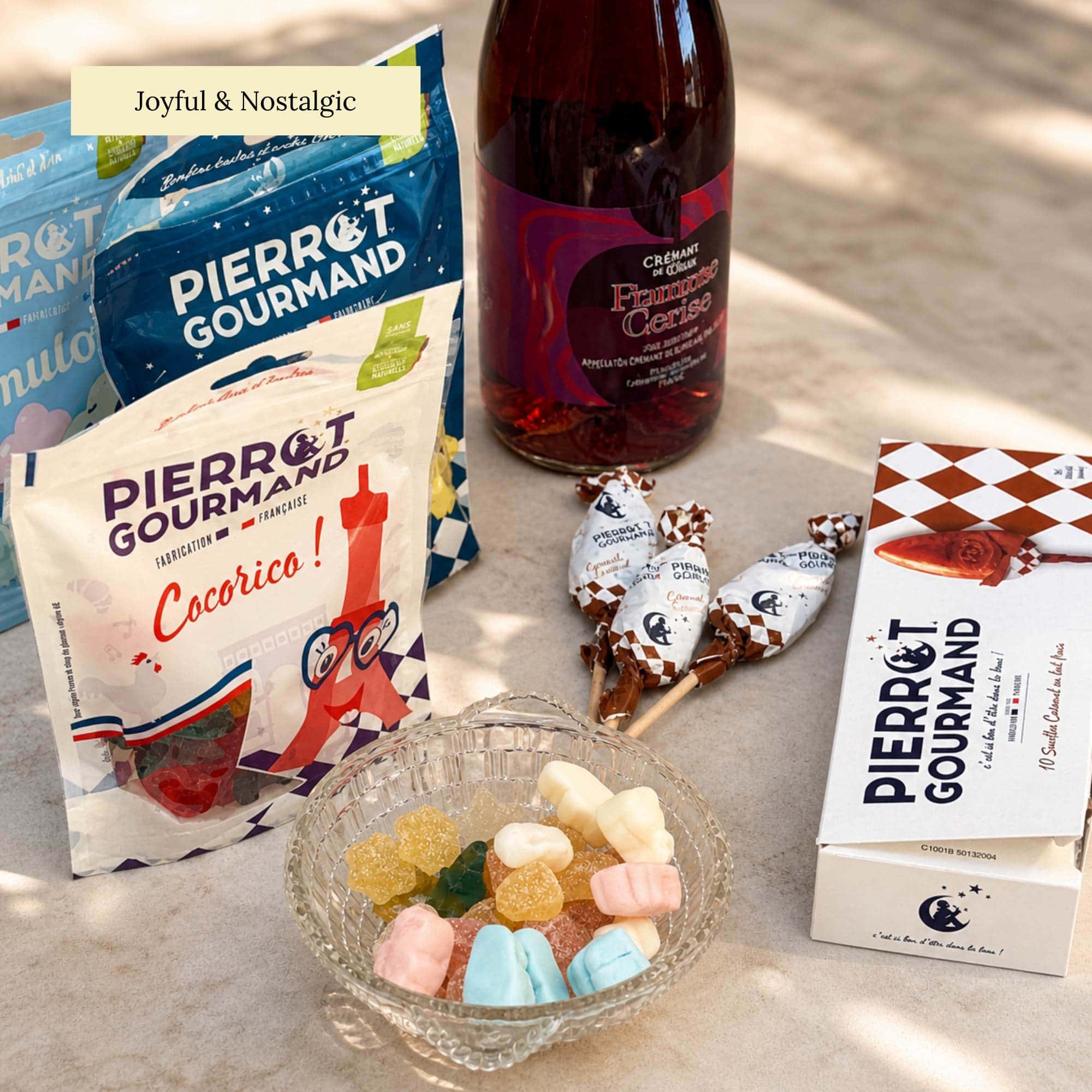 French confectionery set with colourful sweets, caramel lollipops and sparkling fruit drink, styled outdoors