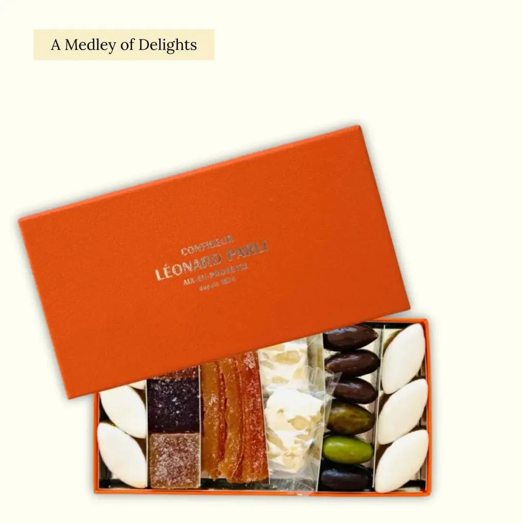 Gift box filled with sweet treats from Provence, including Calissons, Orangettes, fruit pastes, nougat, and chocolate-coated almonds.