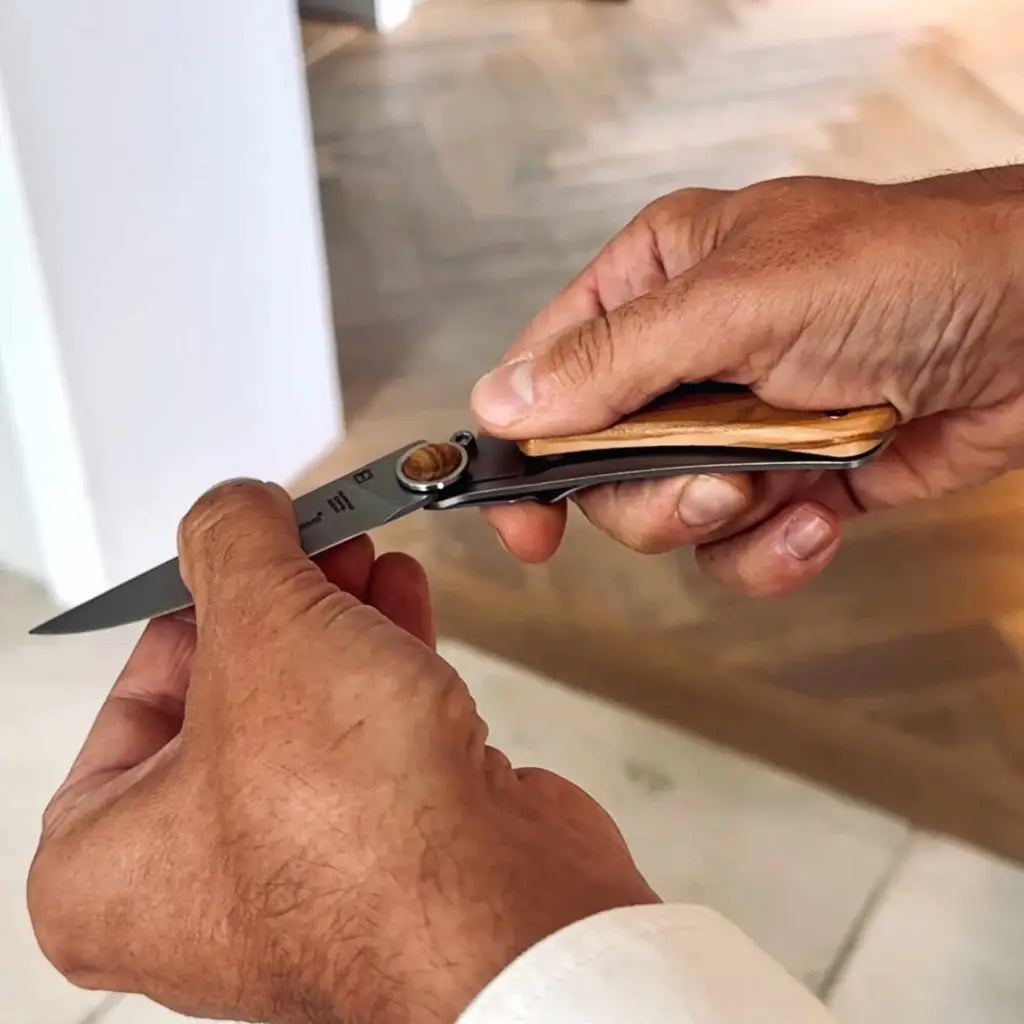 Opening the pocket knife by Claude Dozorme