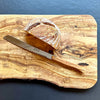 Laguiole bread knife with olive wood handle on olive wood board