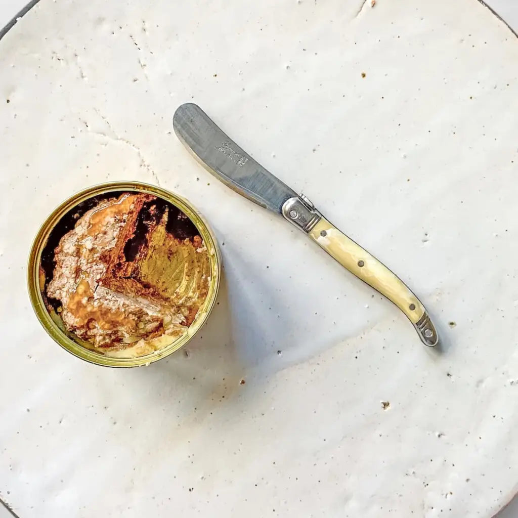 Mini Laguiole spread knife on a ceramic board with a duck terrine