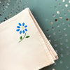 A cheerful set of small vintage French cotton napkins in a soft peach hue.