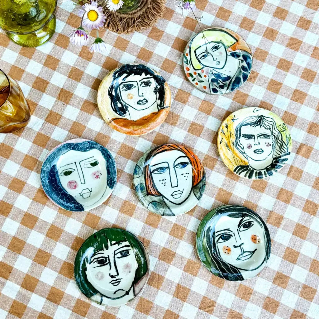 Small plate with painted ladies faces by Elisabeth V. –