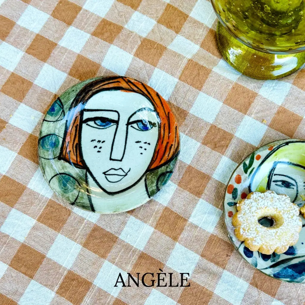Small plate with painted ladies faces by Elisabeth V. –