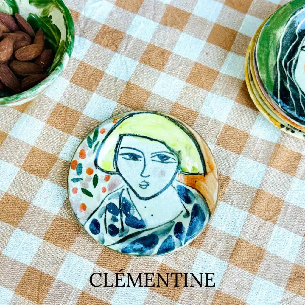 Small plate with painted ladies faces by Elisabeth V. –