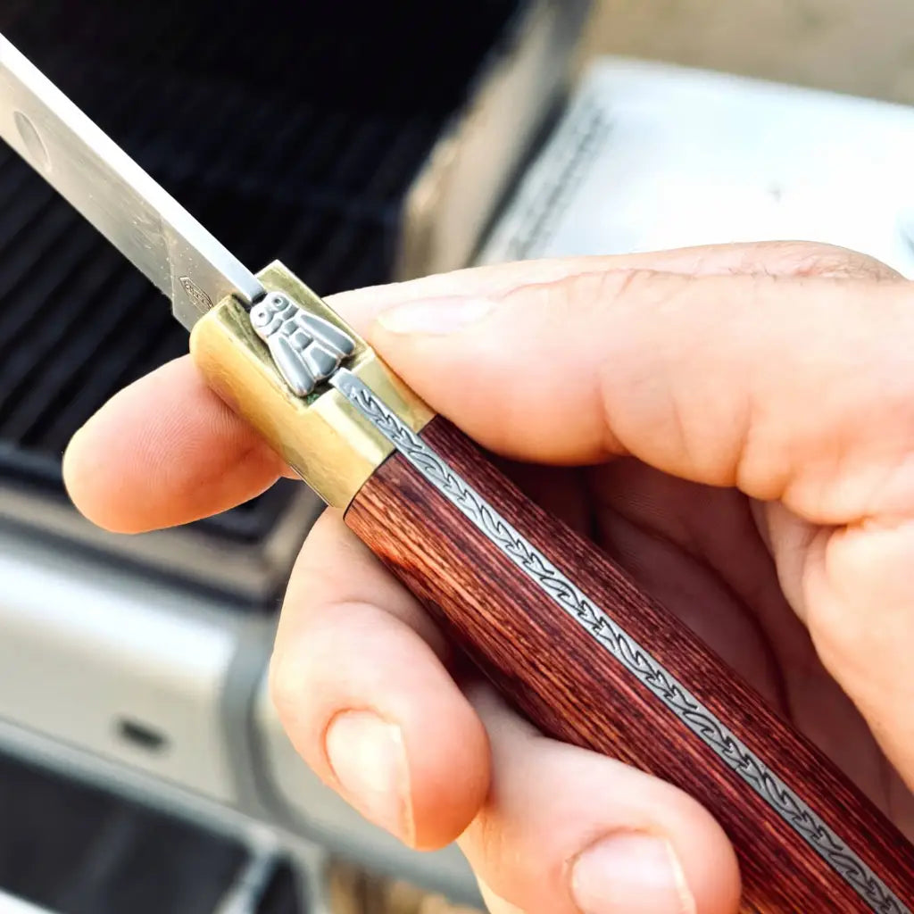 Vintage Laguiole Carving knife. The handle, crafted from rich grained rosewood, is beautifully riveted and finished with the iconic Laguiole bee and decorative spine carving. Wishing a reassuring 225g, it offers excellent balance and control.