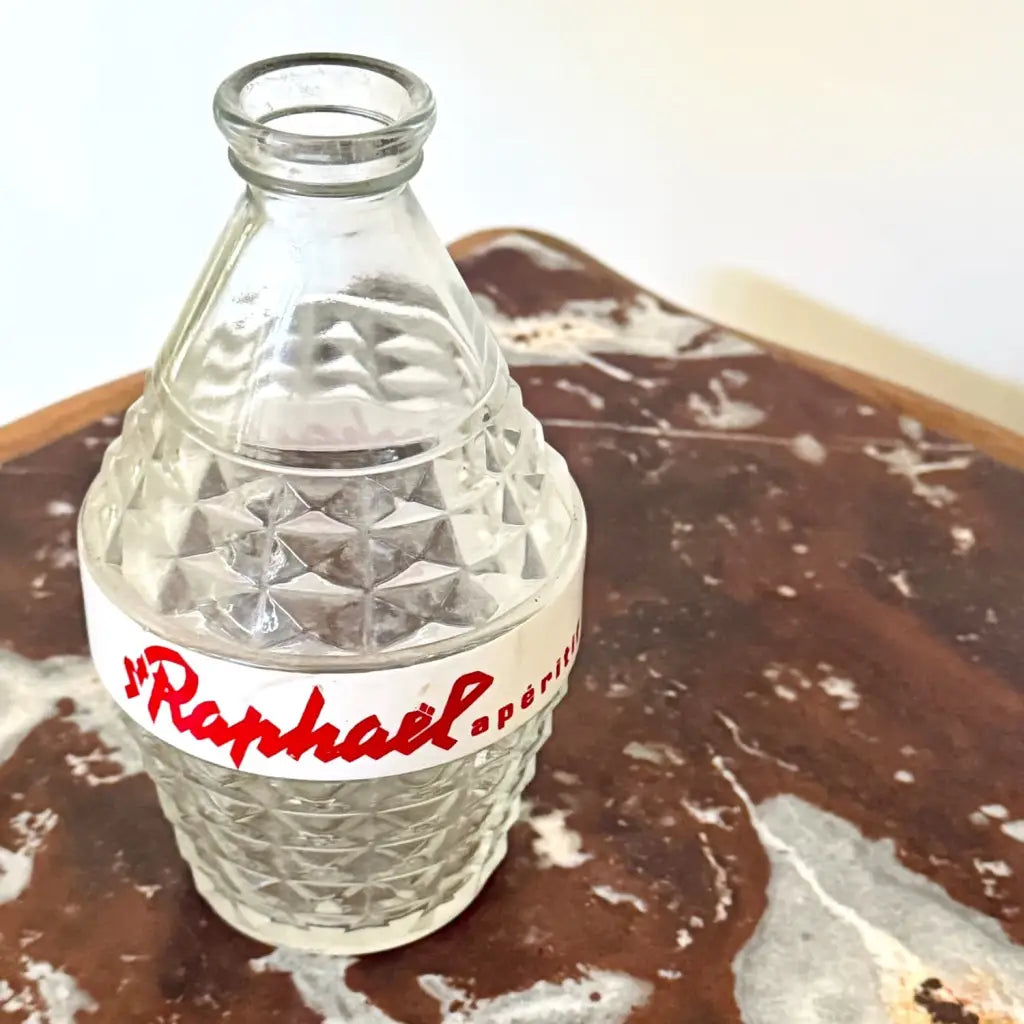 Charming vintage St Raphaël water carafe from the 1960s, made of clear pressed glass with a striking diamond pattern and the iconic red St Raphaël Apéritif lettering across a white enamel band. 